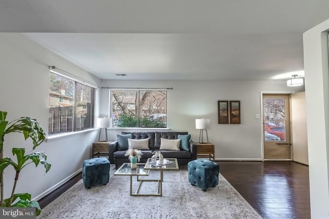 living area with baseboards and dark wood-style flooring