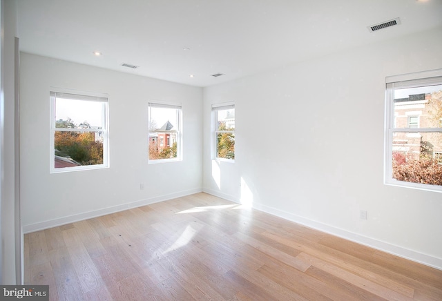 unfurnished room with visible vents, baseboards, and light wood finished floors