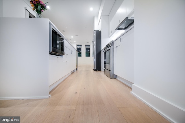 hall with a barn door, recessed lighting, baseboards, and light wood-type flooring