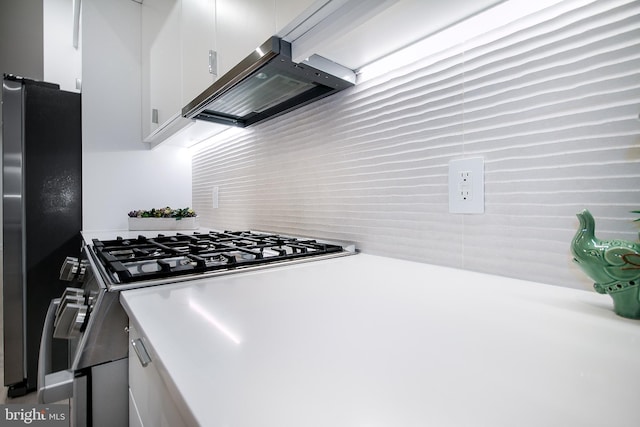 kitchen with extractor fan, appliances with stainless steel finishes, light countertops, and white cabinetry