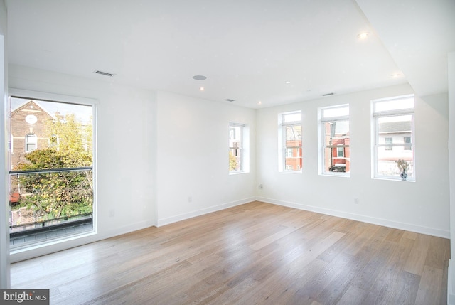 unfurnished room with recessed lighting, visible vents, light wood-style flooring, and baseboards