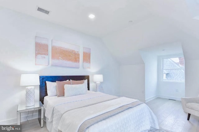 bedroom featuring lofted ceiling, baseboards, and visible vents