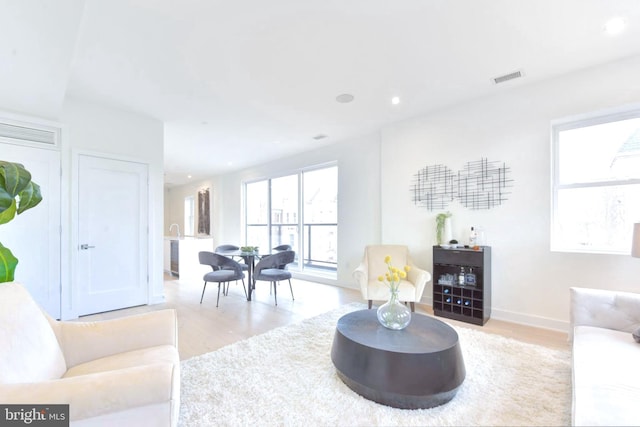 living room featuring visible vents, recessed lighting, and light wood-style flooring