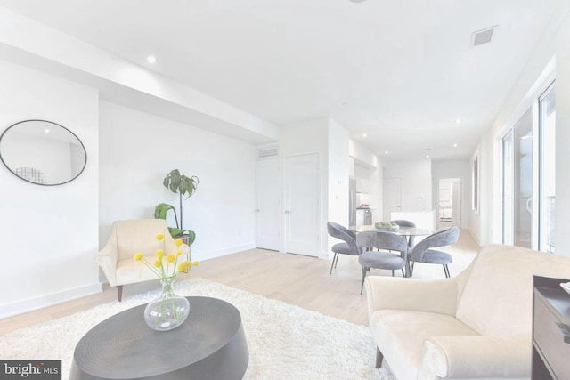 living room with recessed lighting, wood finished floors, visible vents, and baseboards