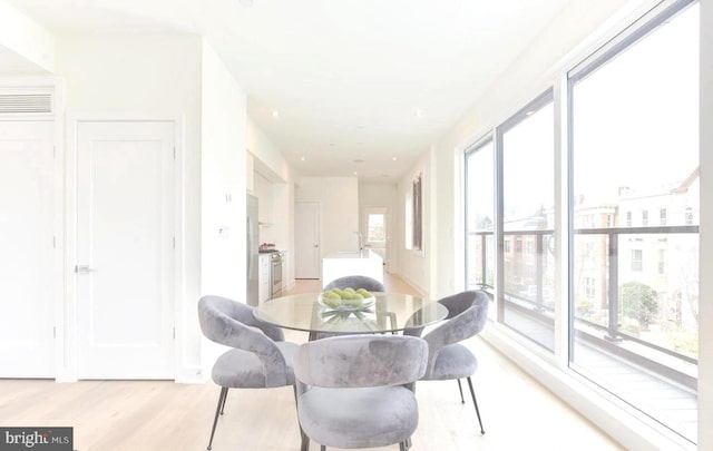 dining room with a wealth of natural light, visible vents, and light wood-style flooring