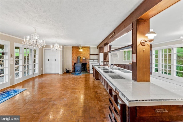 306 Burnt Church Rd, Winchester, VA 22603 - kitchen with a textured ceiling, tile countertops, open floor plan, a wood stove, and a notable chandelier