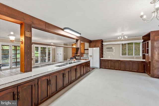 306 Burnt Church Rd, Winchester, VA 22603 - kitchen with a wall mounted AC, tile counters, a chandelier, white refrigerator with ice dispenser, and a sink