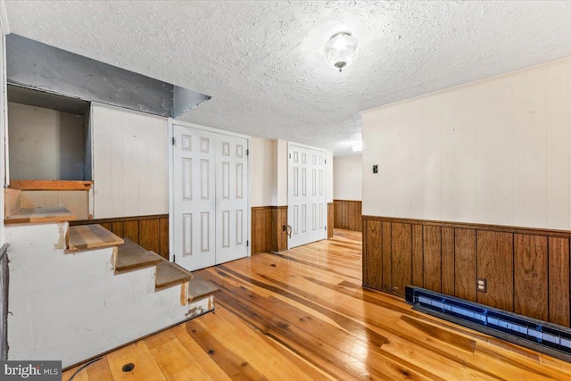 306 Burnt Church Rd, Winchester, VA 22603 - spare room with a wainscoted wall, stairs, a textured ceiling, a baseboard radiator, and hardwood / wood-style floors