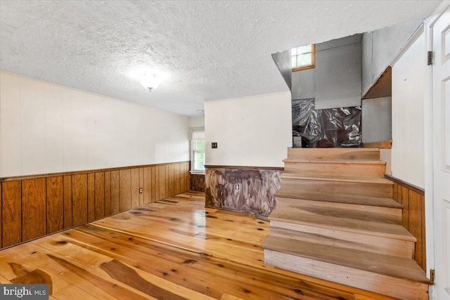 306 Burnt Church Rd, Winchester, VA 22603 - staircase featuring wainscoting, wooden walls, hardwood / wood-style flooring, and a textured ceiling