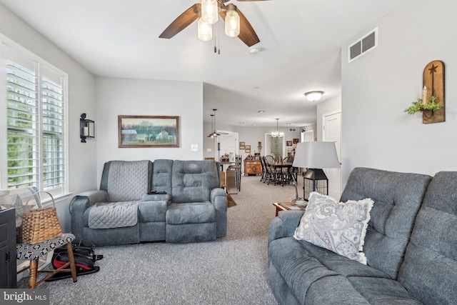 carpeted living area featuring visible vents and ceiling fan