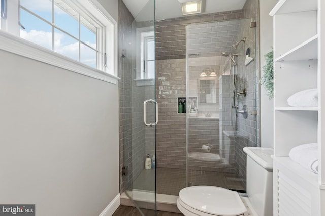 bathroom featuring baseboards, toilet, a stall shower, and vanity