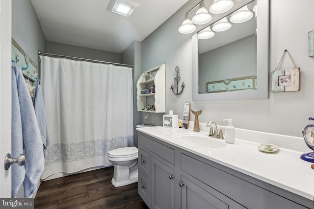 bathroom with curtained shower, toilet, wood finished floors, and vanity