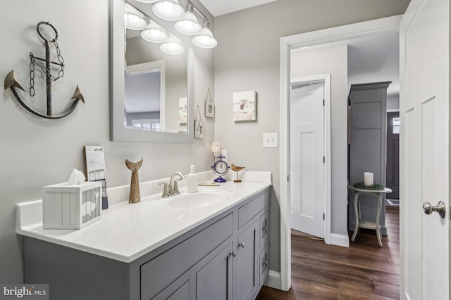 bathroom featuring baseboards, wood finished floors, and vanity