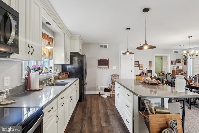 kitchen with dark wood finished floors, visible vents, black microwave, and a sink