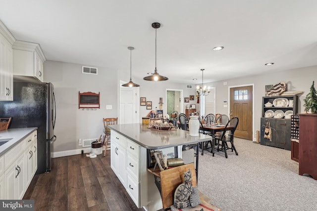 kitchen with white cabinets, visible vents, and a chandelier