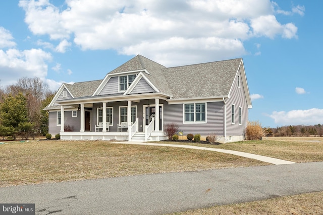 view of front of property featuring a porch, a front lawn, and a shingled roof