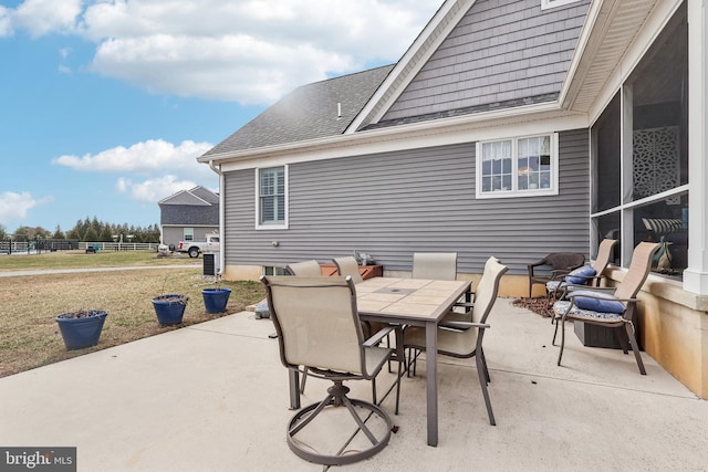 view of patio featuring outdoor dining area and fence