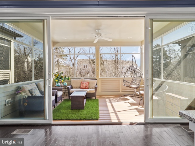 sunroom / solarium with a healthy amount of sunlight and a ceiling fan