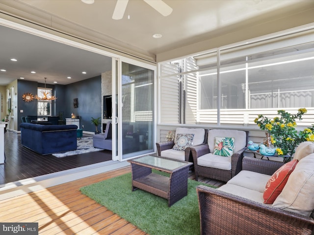 exterior space featuring ceiling fan with notable chandelier