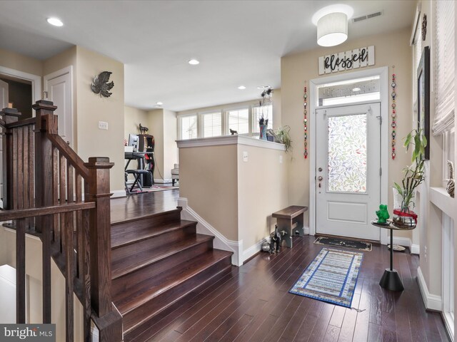 foyer with visible vents, baseboards, stairway, and hardwood / wood-style flooring