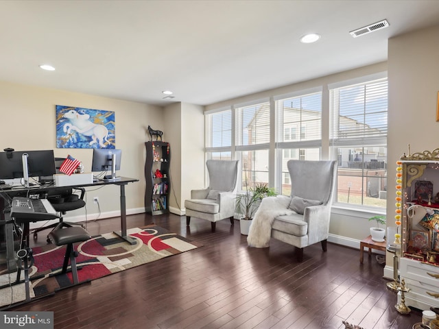 office space featuring plenty of natural light, baseboards, visible vents, and wood finished floors