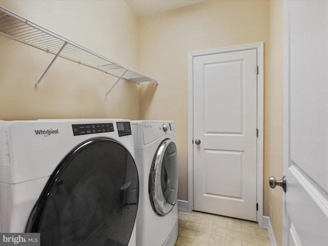 laundry area with baseboards, light floors, independent washer and dryer, and laundry area