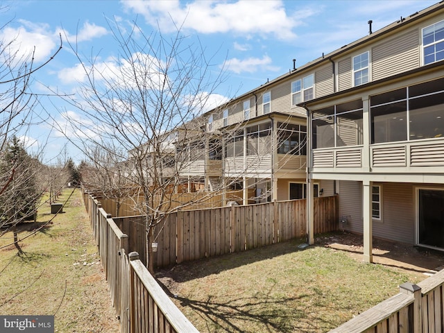 view of yard with a fenced backyard and a sunroom