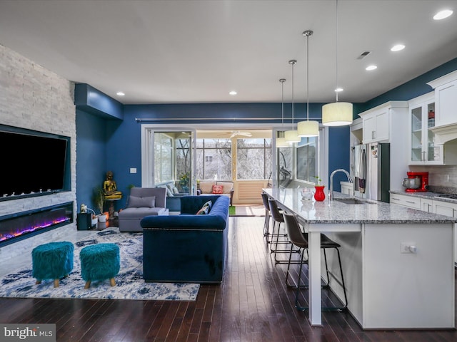 living room with recessed lighting, visible vents, and dark wood-style flooring