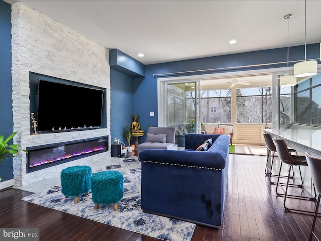 living area with recessed lighting, a fireplace, and hardwood / wood-style floors