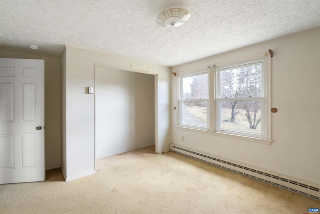 empty room featuring ornamental molding, carpet flooring, baseboard heating, and a textured ceiling