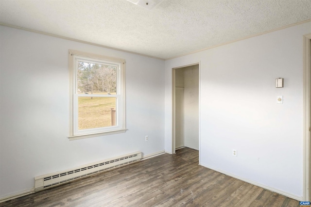 spare room featuring a baseboard radiator, a textured ceiling, wood finished floors, and crown molding