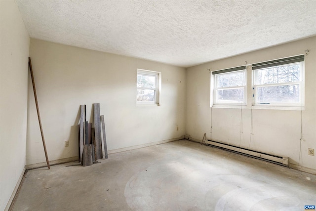 unfurnished room featuring baseboard heating, a textured ceiling, and concrete floors