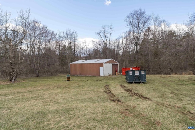 view of yard featuring a view of trees, an outbuilding, and an outdoor structure