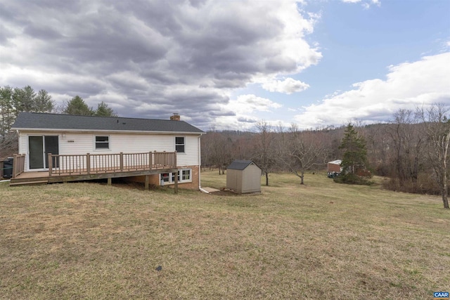 rear view of property with an outbuilding, a wooden deck, a yard, a chimney, and a storage unit