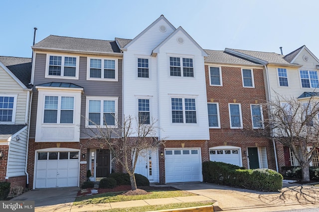 townhome / multi-family property featuring brick siding, an attached garage, and concrete driveway