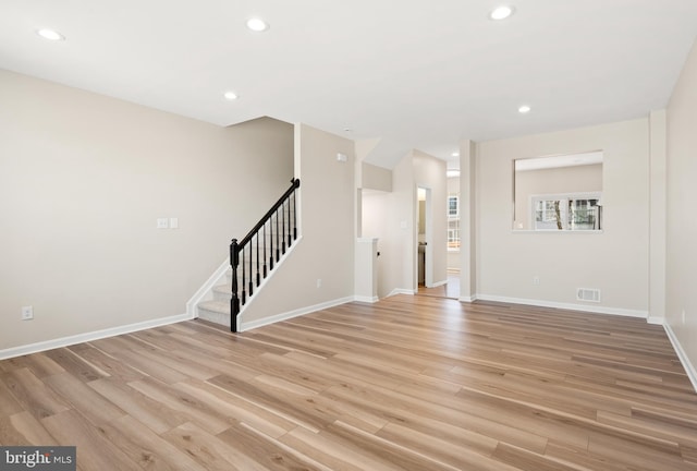 unfurnished living room with recessed lighting, stairway, light wood-style flooring, and visible vents