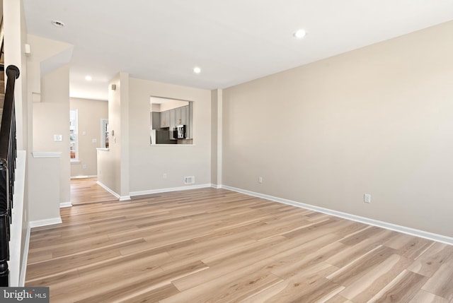 unfurnished living room featuring light wood finished floors, visible vents, recessed lighting, and baseboards