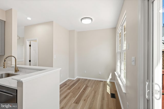 interior space with light wood-type flooring, visible vents, a sink, recessed lighting, and baseboards