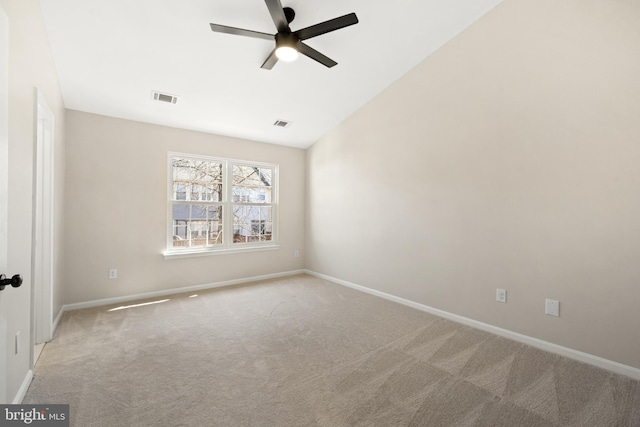 carpeted empty room featuring a ceiling fan, lofted ceiling, baseboards, and visible vents