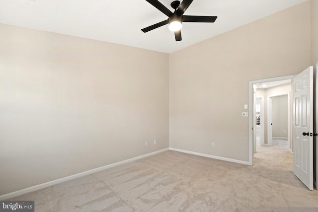 empty room featuring light carpet, ceiling fan, and baseboards