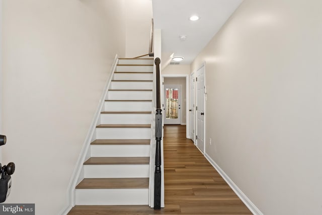 stairway featuring recessed lighting, baseboards, and wood finished floors