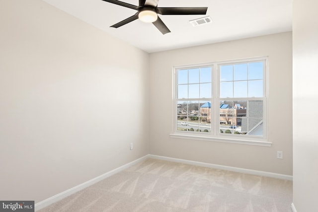 unfurnished room with baseboards, light carpet, visible vents, and ceiling fan