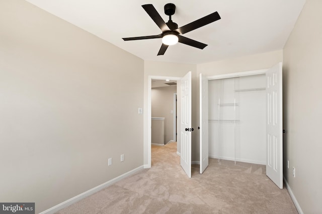 unfurnished bedroom with a ceiling fan, baseboards, a closet, and light carpet