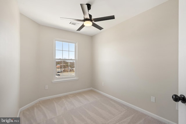 empty room featuring a ceiling fan, visible vents, baseboards, and light carpet