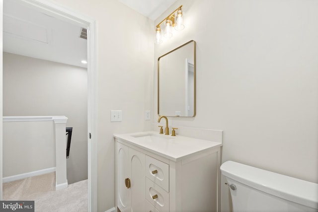 bathroom with vanity, toilet, and baseboards