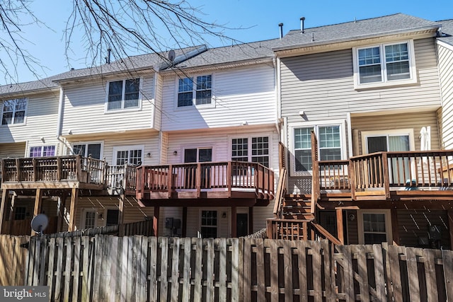 back of property featuring a fenced front yard and a deck