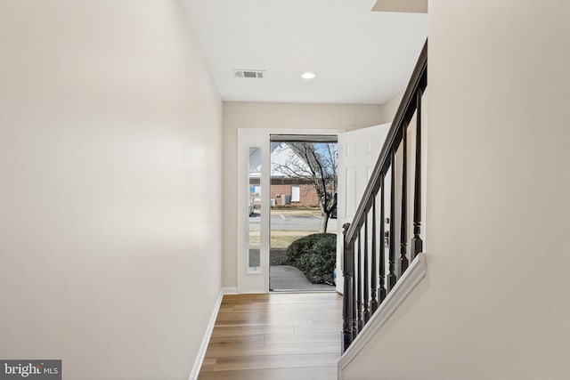 foyer featuring visible vents, baseboards, stairs, recessed lighting, and wood finished floors