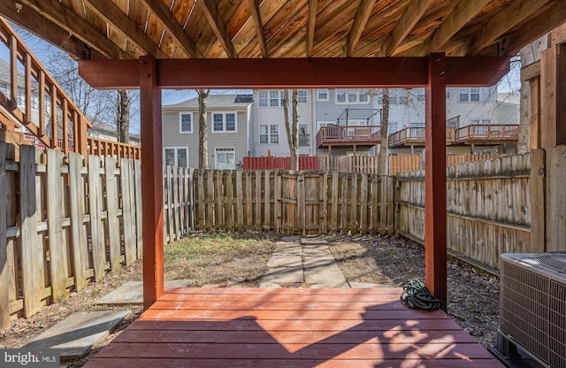 wooden terrace with cooling unit, a residential view, and a fenced backyard