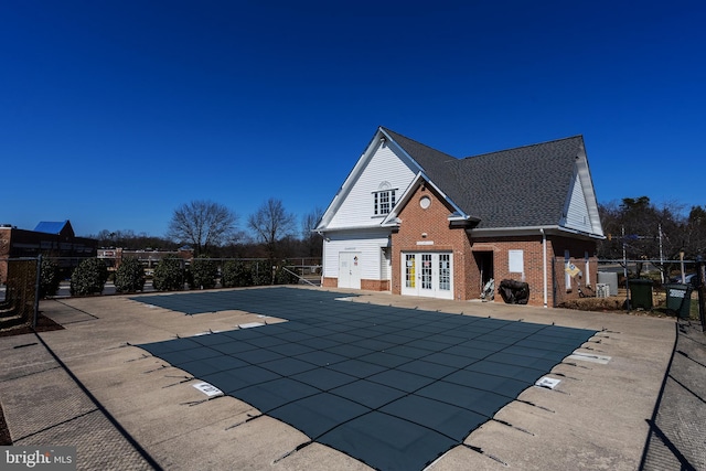 pool with a patio, french doors, and fence