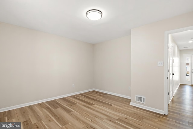 unfurnished room featuring baseboards, visible vents, and light wood finished floors